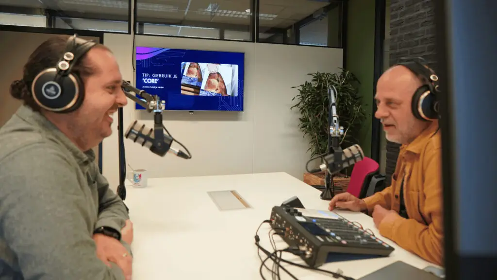 2 mensen tegenover elkaar die een podcast opnemen