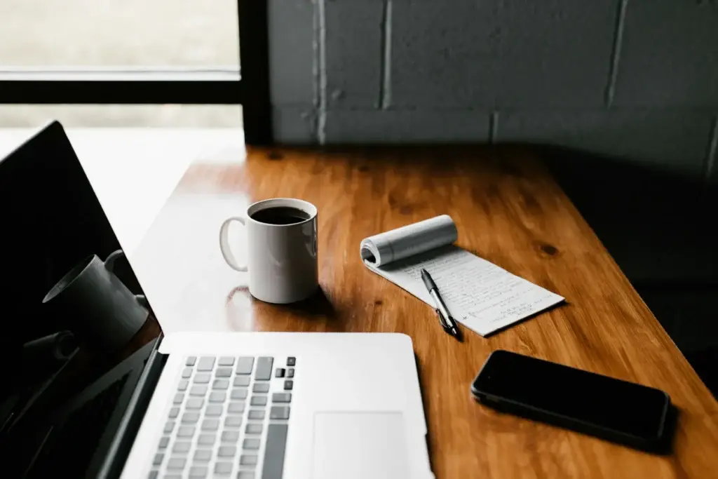 Laptop, koffie en notitieboek op een houten bureau voor een Corsa zaakbehandeling