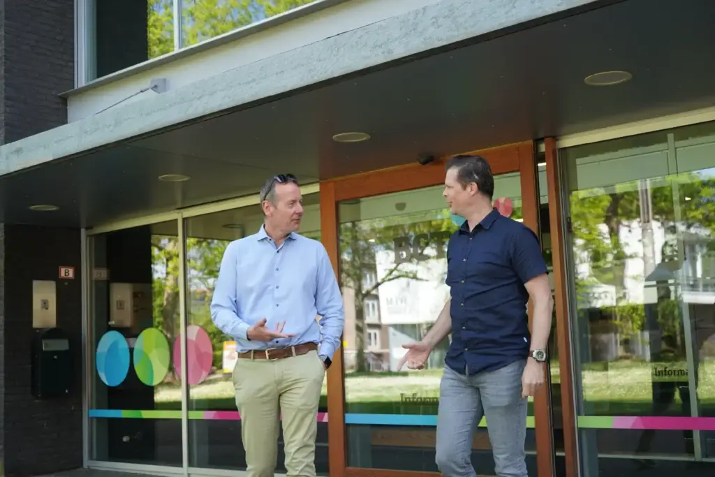 Twee professionals in gesprek bij de ingang van het BCT-kantoor in Sittard