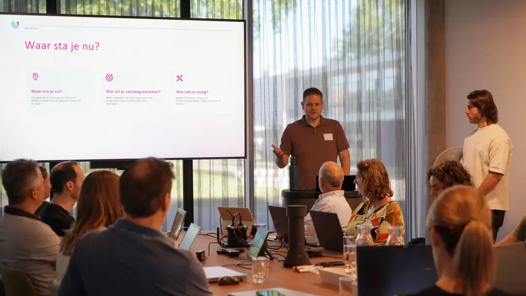 Twee consultants leiden een groep deelnemers door een Samen op Koers sessie