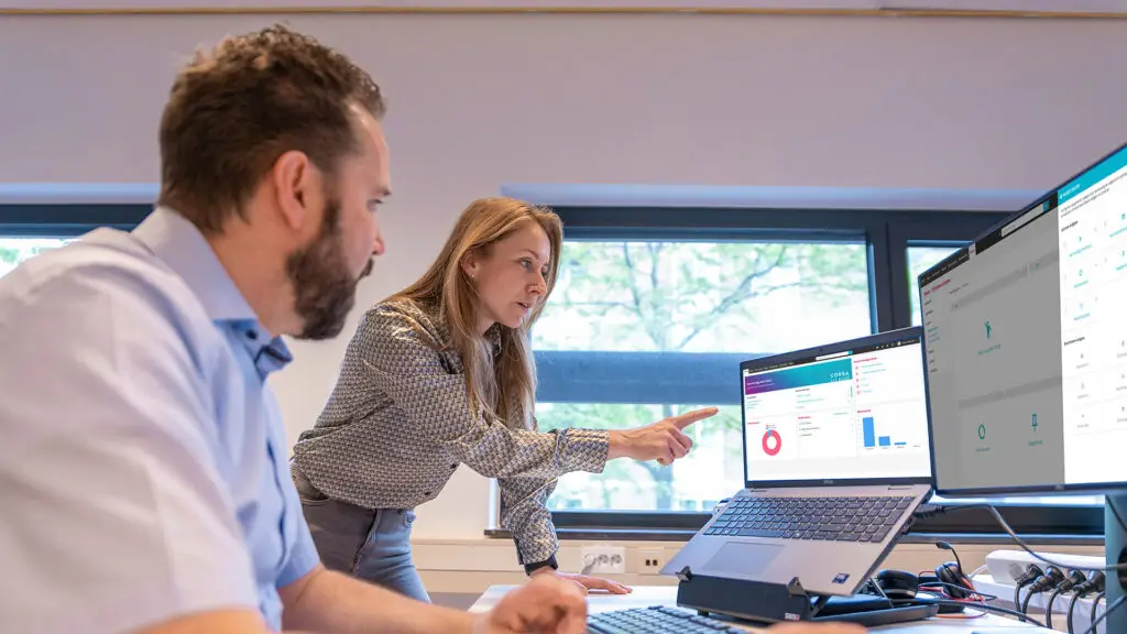 Medewerkster wijzend naar monitor waarop Corsa te zien is